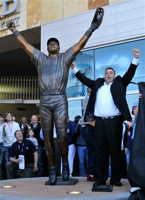 Kent Hrbek poses next to his bronze sculpture